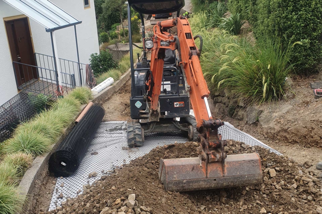 excavator working on the ground near a house
